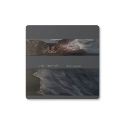 At the Water’s Edge art coaster by Jennifer F, featuring horizontal sections of a dark coastal painting with rugged shoreline, deep blue-grey water and lighter areas of moving sea.