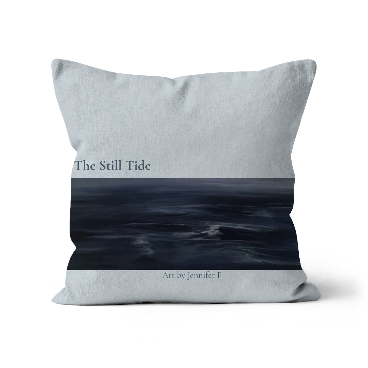 The Still Tide art cushion by Jennifer F, featuring a misty seascape with a pale grey-blue sky, deep blue water and small white highlights across the sea.