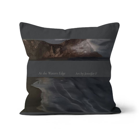 At the Water’s Edge art cushion by Jennifer F, featuring a dark coastal painting with dramatic clouds, rocky shoreline and deep blue-grey water.